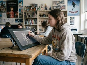 Jeune femme en hoodie crée une sculpture 3D en classe